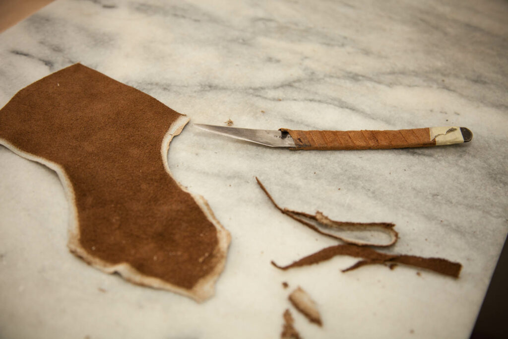 Das Leder für Maßschuhe wird mit einem scharfen Messer zugeschnitten